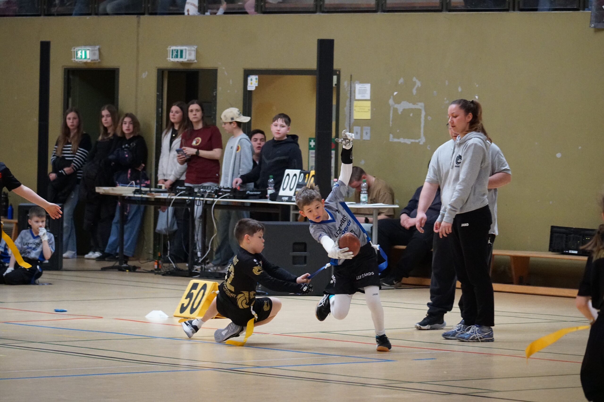 Ein Spieler fängt den Ball, während ein Spieler der gegnerischen Mannschaft versucht, seine Flagge zu ziehen.