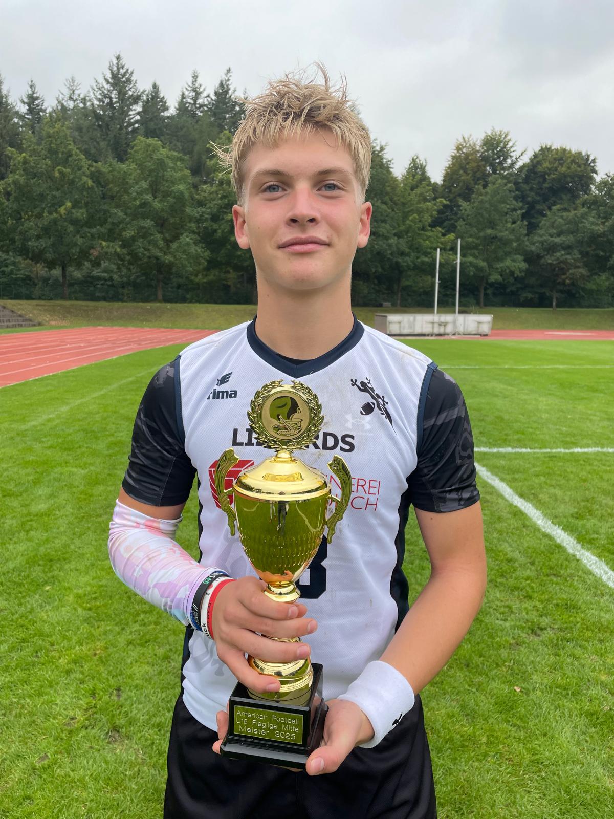 Eine Nahaufnahme von MVP Daniel Bleul, der die Trophäe in der Hand hält.