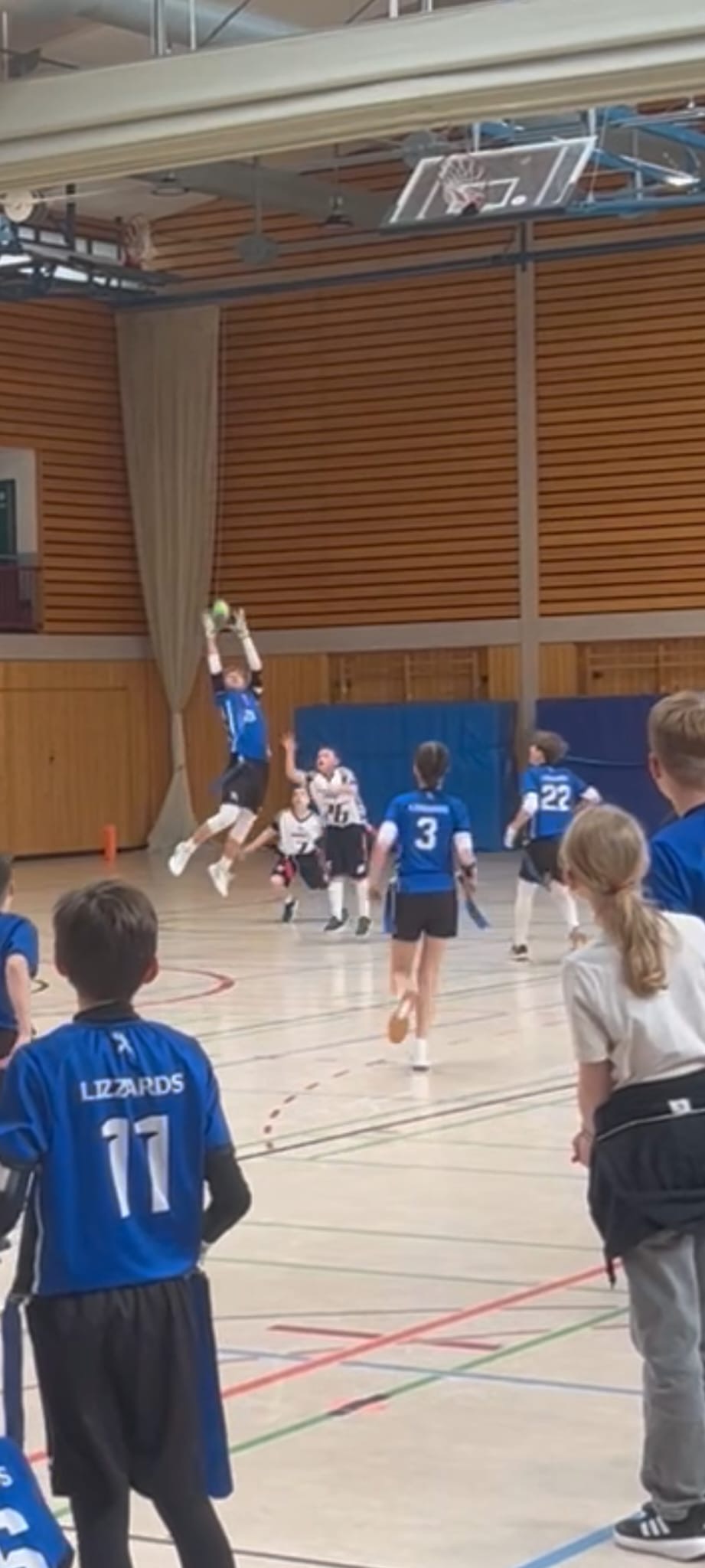 Eine Fernaufnahme eines Lizzards-Spielers, der in die Luft springt, um den Ball zu fangen.