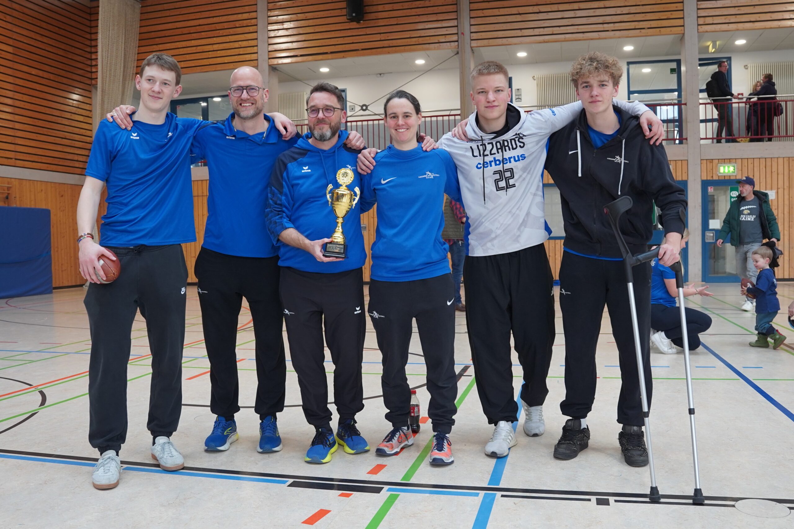 Gruppenfoto des Trainerteams der Lizzards mit dem Pokal.
