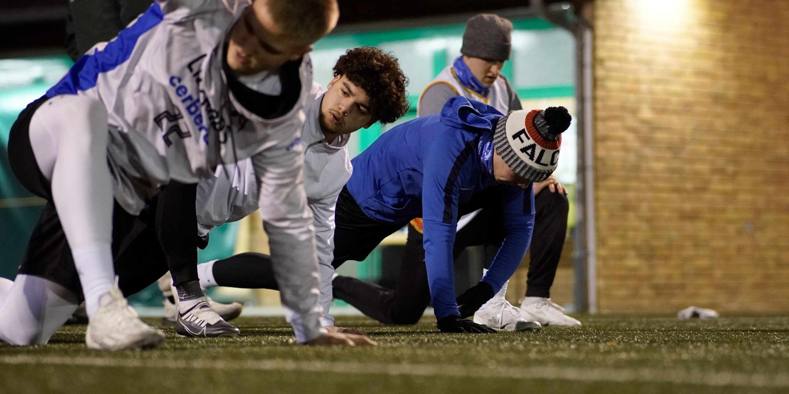 Lizzards-Spieler trainieren nachts auf einem Rasenfeld.