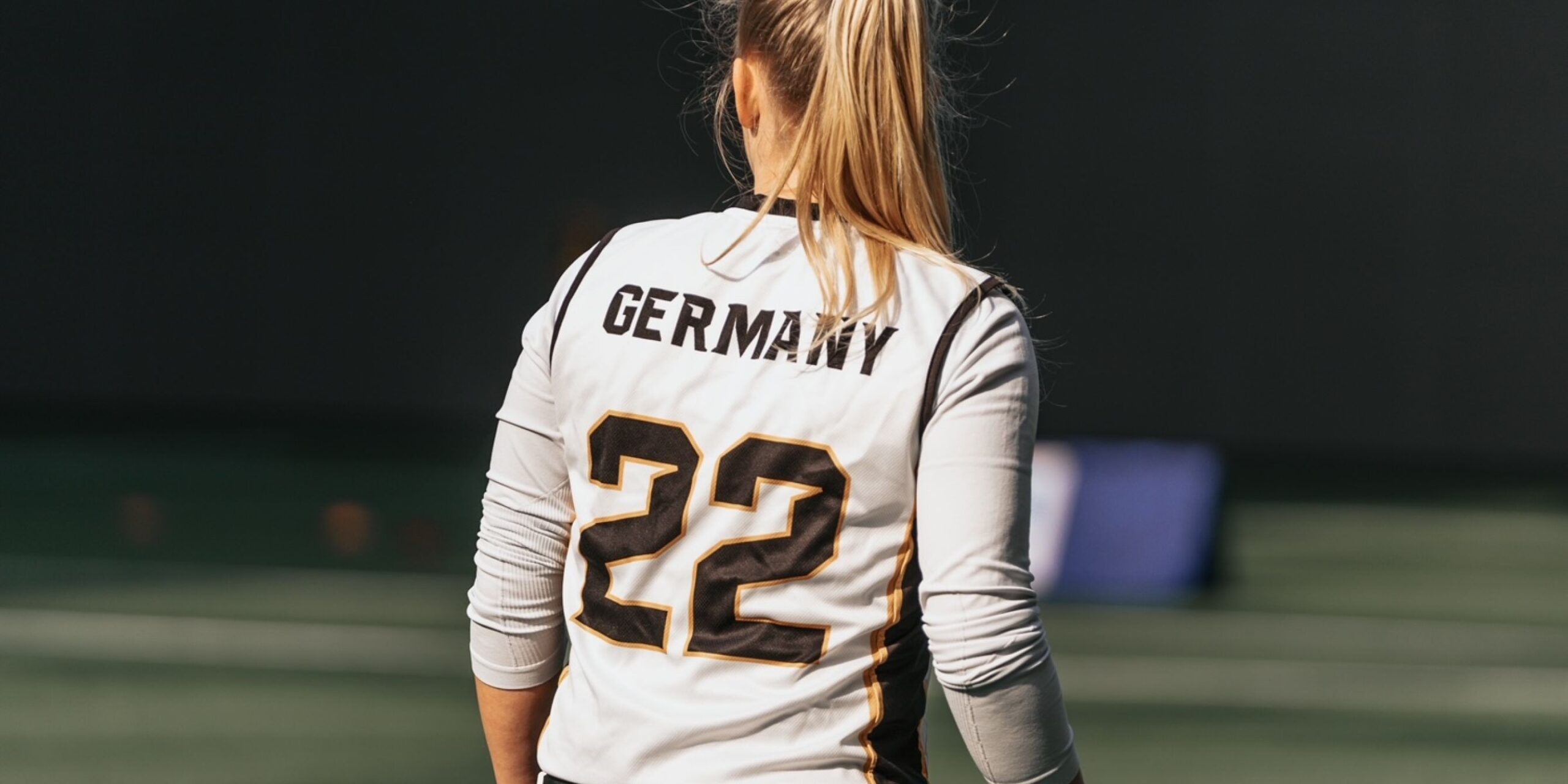 Ein Mädchen, das ein Sporttrikot mit der Aufschrift „Germany 22” trägt.