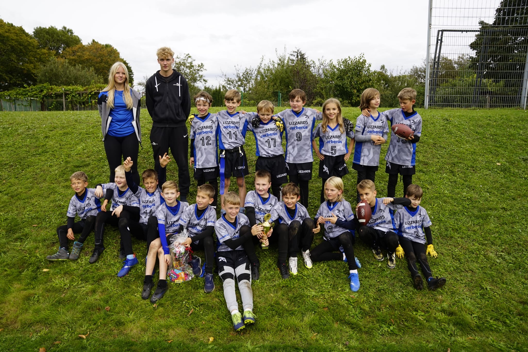 Gruppenfoto der Junioren U10 auf dem Spielfeld mit ihren beiden Trainern.