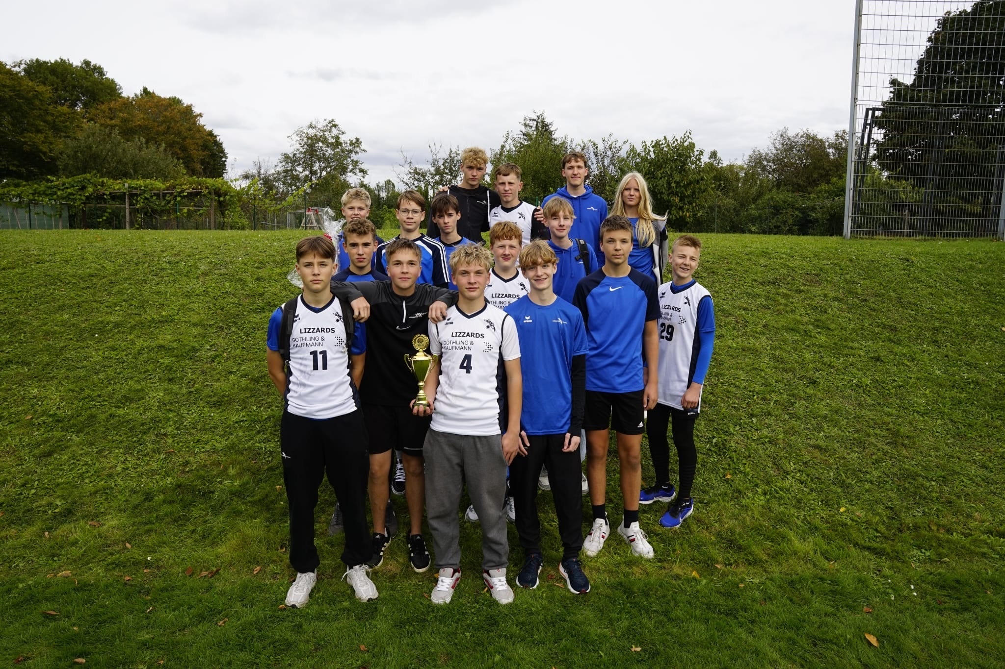 Junioren U16 Gruppenfoto mit ihren Trainern und dem Pokal.
