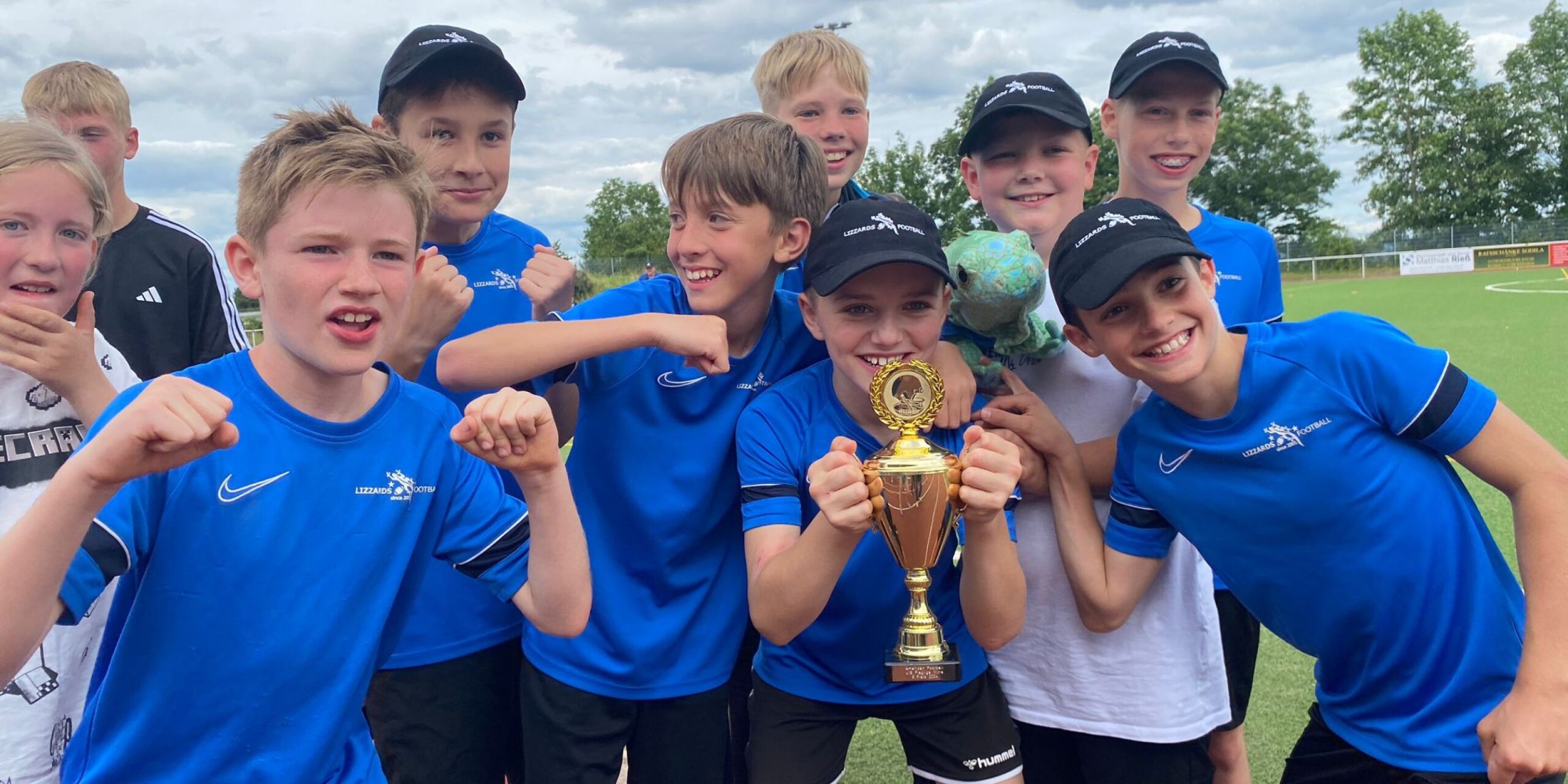 Die Juniorenmannschaft U13 posiert fröhlich mit dem Pokal in den Händen.
