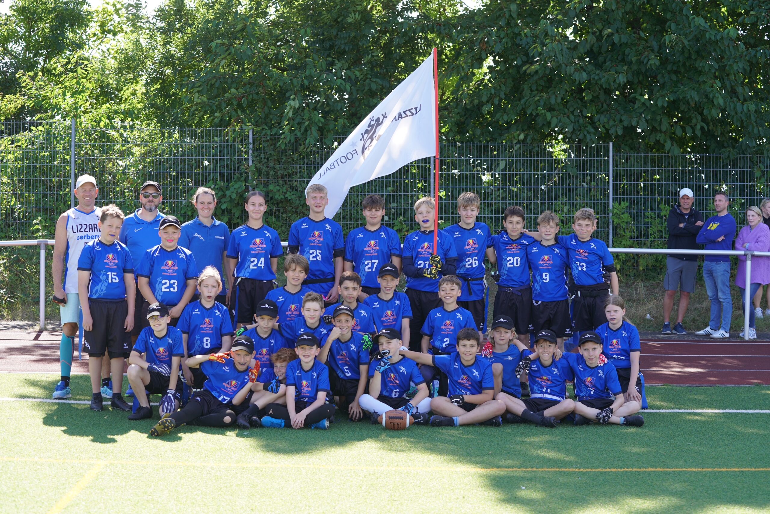 Gruppenfoto der Junioren U13 mit der Flagge des Lizzards Football Clubs.