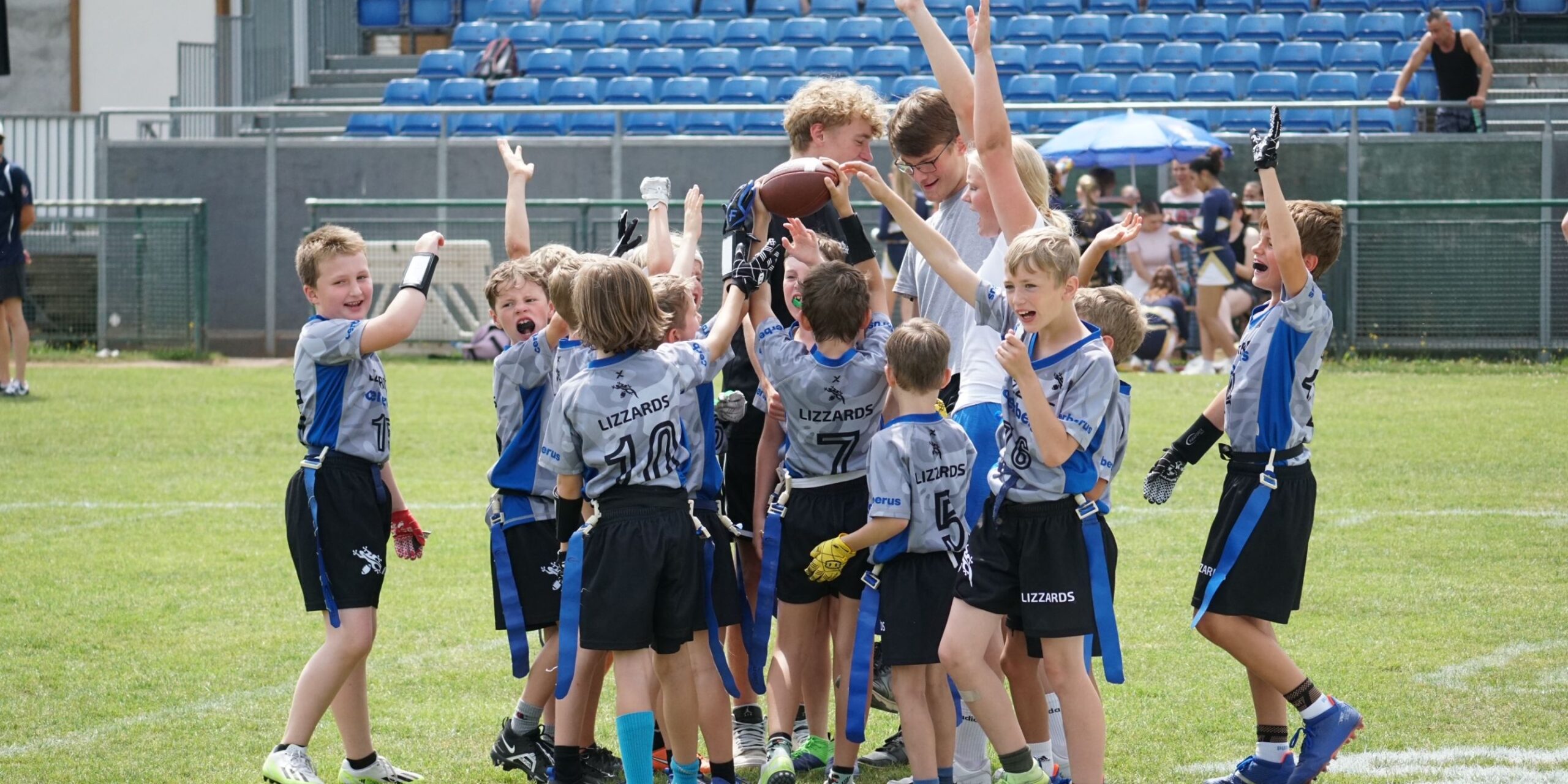 Junioren U10-Spieler jubeln auf dem Spielfeld mit erhobenen Händen