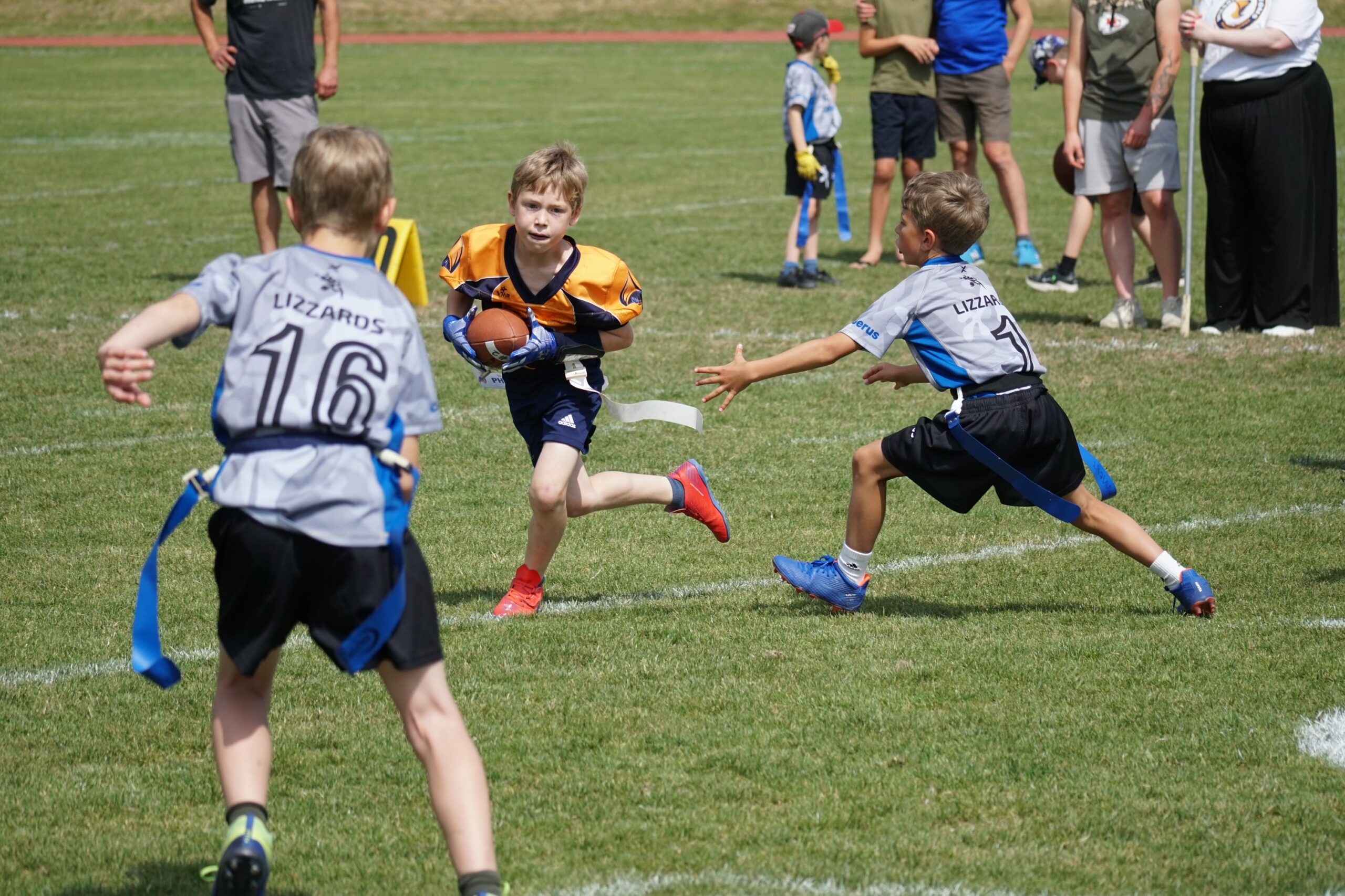 Der gegnerische U10-Spieler verteidigt den Ball gegen zwei Spieler der Kelkheim Lizzards U10.